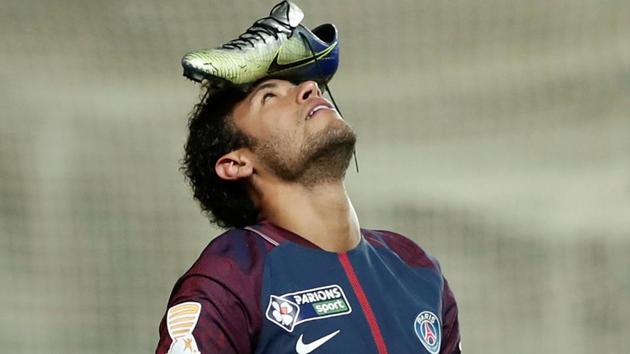 Paris Saint-Germain’s Neymar celebrates scoring their first goal from the penalty spot with his football boot on his head.(Reuters)