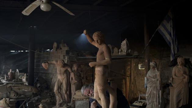 Goumas works on detailing a terracotta statue of Hermes. Although past retirement age, he hopes to continue working and at the same time to create a school for young artists on the site. (Petros Giannakouris / AP)