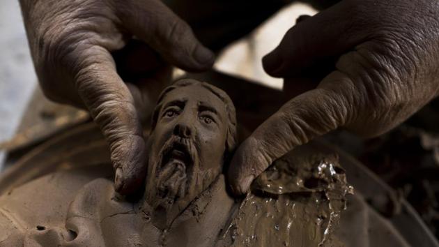 Haralambos Goumas works on a terracotta flower pot decorated with the face of Poseidon, the ancient Greek god of the sea at his workshop. (Petros Giannakouris / AP)