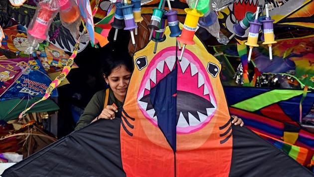 A young woman checks out a huge kite shaped like a ferocious shark in Bandra. (Satyabrata Tripathy/HT Photo)