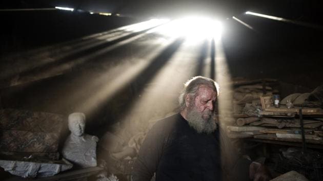 Rays of sunlight shine on Haralambos Goumas as he works in his workshop. His pieces are a rare survival of a vanishing art in recession-plagued Greece, all made by hand using traditional techniques in a western Athens workshop squeezed in among warehouses, small industries and a railyard. (Petros Giannakouris / AP)