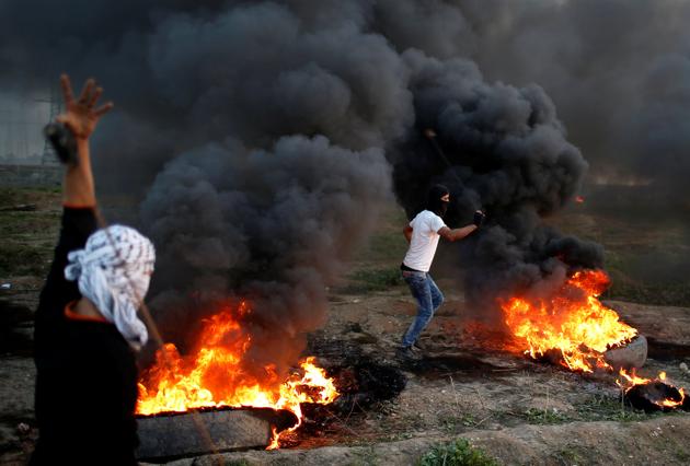 Palestinian demonstrators use slings to hurl stones at Israeli troops during clashes, near the border with Israel in the east of Gaza City January 12, 2018.(REUTERS)