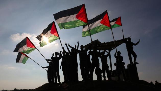 Palestinian protesters wave their national flag near the Israel-Gaza border east of the southern Gaza Strip city of Khan Yunis demonstrating against calls for the closure of UNRWA by the Israeli prime minister and cuts in Palestinian aid by the American president on January 9, 2018. (Said Khartib / AFP) Palestinian protesters wave their national flag near the Israel-Gaza border east of the southern Gaza Strip city of Khan Yunis demonstrating against calls for the closure of UNRWA by the Israeli prime minister and cuts in Palestinian aid by the American president on January 9, 2018. (Said Khartib / AFP)