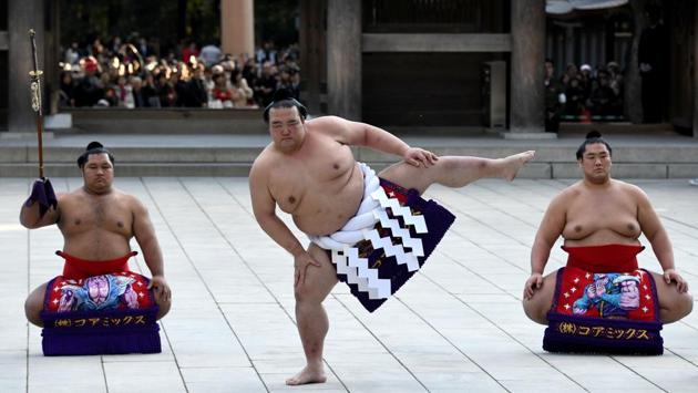 Sumo grand champion Kisenosato (C), performs a ring-entering ceremony beside sword carrier Shohozan (L) and dew sweeper Kagayaki (R) at Meiji shrine in Tokyo on January 9, 2018. Sumo’s three grand champions clapped their hands and stamped their feet in a traditional New Year offering to the Shinto gods, as the sport seeks to turn the page on a scandal-hit 2017. (Toshifumi Kitamura / AFP) Sumo grand champion Kisenosato (C), performs a ring-entering ceremony beside sword carrier Shohozan (L) and dew sweeper Kagayaki (R) at Meiji shrine in Tokyo on January 9, 2018. Sumo’s three grand champions clapped their hands and stamped their feet in a traditional New Year offering to the Shinto gods, as the sport seeks to turn the page on a scandal-hit 2017. (Toshifumi Kitamura / AFP)