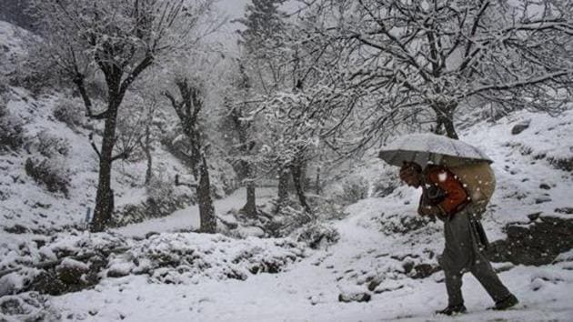 An elderly man, carrying a load on his back, walks on a snow covered road during snowfall at Tangmarg in Baramulla district of north Kashmir. (PTI File Photo) An elderly man, carrying a load on his back, walks on a snow covered road during snowfall at Tangmarg in Baramulla district of north Kashmir. (PTI File Photo)