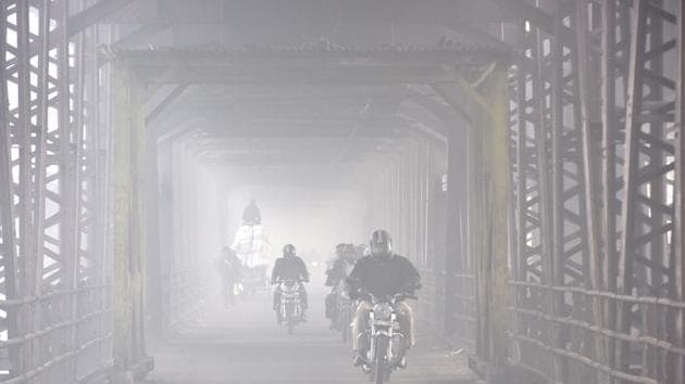 File photo of commuters riding through thick of fog in New Delhi.(HT PHOTO)