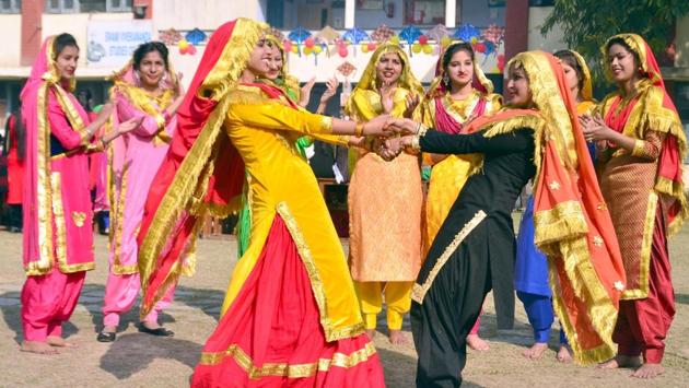 Students wearing traditional Punjabi dresses dance during Lohri in Amritsar. (Sameer Sehgal / HT Photo)