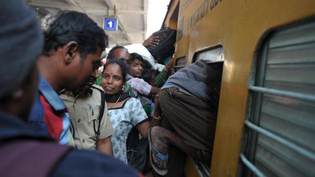 A passenger climbs into a train bound for coastal districts in the state of Andhra Pradesh at Secunderabad Railway Station in Hyderabad. (Noah SEELAM / AFP)