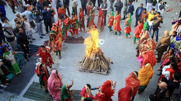 Girls wearing traditional attire dance around a bonfire as they celebrate Lohri in Jammu. (PTI) Girls wearing traditional attire dance around a bonfire as they celebrate Lohri in Jammu. (PTI)