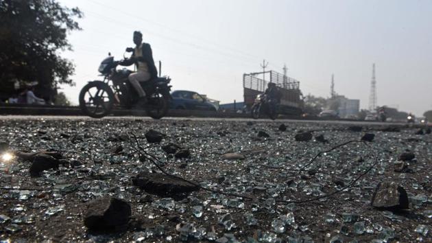 Pieces of broken glass lying on the road at Sanaswadi after the violence in the city on Tuesday. (Pratham Gokhale/HT Photo) 