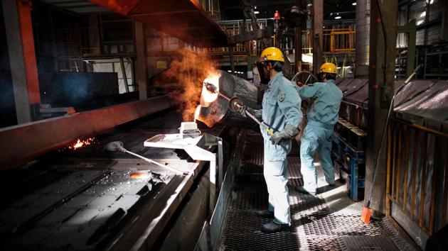 Workers pour molten metal into a manhole cover mold at a factory. The history of decorating manhole covers in Japan dates back 40 years to a bid to improve the image of the sewerage system. (Behrouz Mehri / AFP) Workers pour molten metal into a manhole cover mold at a factory. The history of decorating manhole covers in Japan dates back 40 years to a bid to improve the image of the sewerage system. (Behrouz Mehri / AFP)