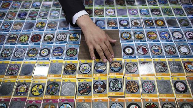 A collection of designed manhole cover cards in Tokyo. The designs have spawned a collection craze among so-called “manholers.” Given their size, covers cannot easily be collected in the same way people hoard stamps and coins. To satisfy demand, the private-public GKP network designed to promote awareness on the importance of sewerage has released 1.4 million cards of 293 different covers. (Behrouz Mehri / AFP) A collection of designed manhole cover cards in Tokyo. The designs have spawned a collection craze among so-called “manholers.” Given their size, covers cannot easily be collected in the same way people hoard stamps and coins. To satisfy demand, the private-public GKP network designed to promote awareness on the importance of sewerage has released 1.4 million cards of 293 different covers. (Behrouz Mehri / AFP)