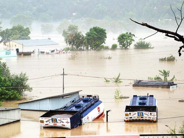 Houses are submerged as trucks flow in flood waters of the Bhagirathi River in Shrinagar district Uttarakhand. AP Houses are submerged as trucks flow in flood waters of the Bhagirathi River in Shrinagar district Uttarakhand. AP