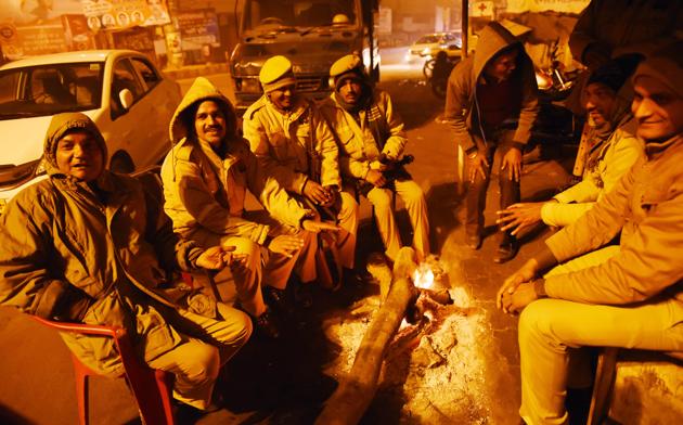 Security personnel sit around a bonfire near KGMU crossing in Lucknow. (Subhankar Chakraborty/HT Photo) Security personnel sit around a bonfire near KGMU crossing in Lucknow. (Subhankar Chakraborty/HT Photo)
