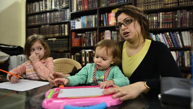 Chaya and her children surrounded by shelves of texts on Judaism at the Chabad House. While the family initially had difficulty finding kosher food, a kitchen the Chabad House runs now extends its facilities to travellers. As they continue to attend to visitors and give lessons in Judaism, the only draws to Israel that remain are visits to family or the Jewish education that awaits their children in the future. (Sanchit Khanna / HT Photo) Chaya and her children surrounded by shelves of texts on Judaism at the Chabad House. While the family initially had difficulty finding kosher food, a kitchen the Chabad House runs now extends its facilities to travellers. As they continue to attend to visitors and give lessons in Judaism, the only draws to Israel that remain are visits to family or the Jewish education that awaits their children in the future. (Sanchit Khanna / HT Photo)