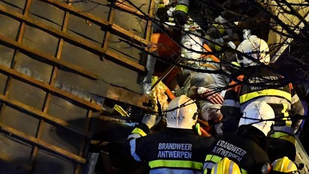 Firefighters rescue a man following the collapse of a building, at the Paardenmarkt in Antwerp on January 15 after several buildings collapsed following an explosion.(AFP)