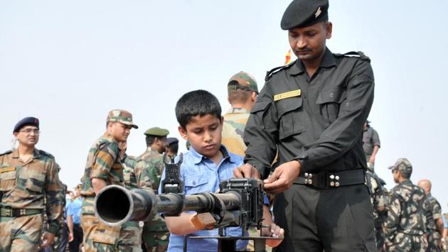 A child looks at a  weapon during the Army fire drill at KK Range, Ahmednagar in Pune. (HT PHOTO) 