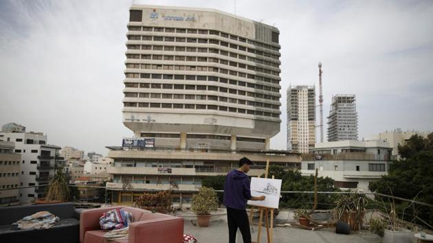 Amateur painter Kobi Malul, 31, lends strokes to a piece on his rooftop in central Tel Aviv. (Corinna Kern / REUTERS)
