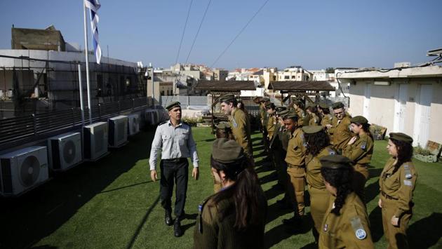 Israeli soldiers prepare for a parade in front of the master-sergeant who is checking their appearance, on the rooftop of the Israeli Defence Forces Galgalatz radio station, in Tel Aviv. This routine takes place twice a week and occurs frequently on the station's rooftop. (Corinna Kern / REUTERS)