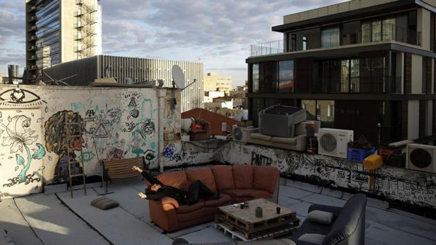 Guy Elhadad, 26, lies on a sofa on his rooftop in Tel Aviv. For Guy his rooftop is his creative incubator, "where we can do whatever we want because we don't need the approval of others". He and two roommates host yoga, music and art sessions here and built a spare sleeping place for people passing through. Elhadad said he loves Tel Aviv and through his rooftop can help make it bloom. (Corinna Kern / REUTERS)