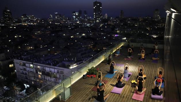 People participate in a late evening yoga class on the rooftop of a Tel Aviv municipality building. (Corinna Kern / REUTERS)