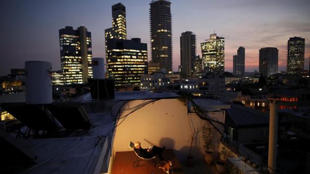 Alexander Flaschenberg, 60, sits on a chair placed on top of a table, in order to enjoy view of the sea from his rooftop in Tel Aviv. The rooftop is a personal haven for Alexander, giving him an opportunity to unwind from work. (Corinna Kern / REUTERS)