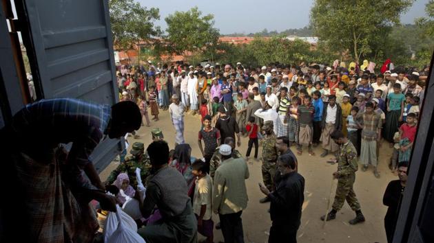 Rohingya refugee stand and watch as others receive relief material at Kutupalong refugee camp near Cox's bazar, Bangladesh on January 16.(AP Photo)
