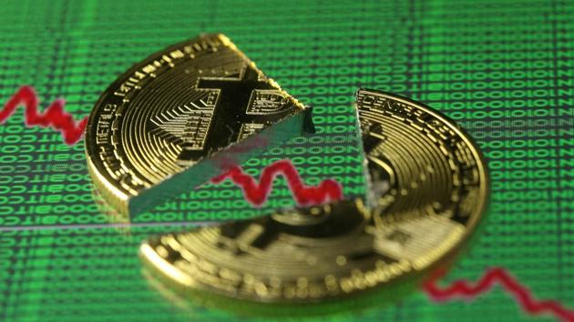 Broken representation of the Bitcoin virtual currency, placed on a monitor that displays stock graph and binary codes, are seen in this illustration picture. (Reuters)