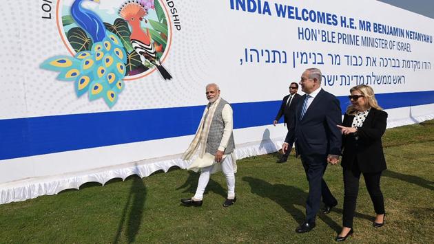 Narendra Modi (L), Israeli Prime Minister Benjamin Netanyahu (C) and his wife Sara Natanyahu walk past a billboard during an official visit to Ahmedabad. Modi and Netanyahu inaugurated the iCreate Centre at Deo Dholera village later in the afternoon. They will also visit a Startup Exhibition and interact with innovators and Startup CEOs. (AFP / PIB)