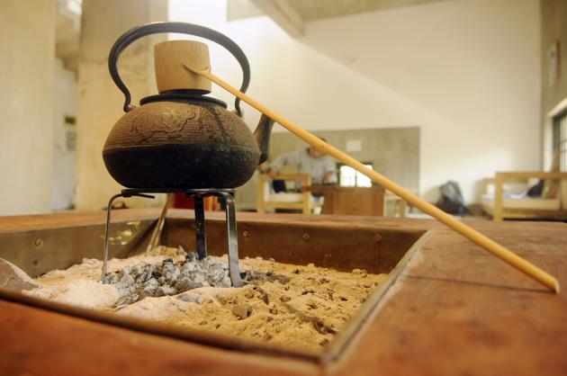 Near the tokonoma is a low square table with a sunken hearth. As charcoal burns in the hearth, a black iron kettle placed on top keeps the tea – so central to Japanese life – warm. All the tables are designed for sitting on the floor and wooden fixtures, instead of nails, have been used to make them. (Samir Jana / HT Photo) Near the tokonoma is a low square table with a sunken hearth. As charcoal burns in the hearth, a black iron kettle placed on top keeps the tea – so central to Japanese life – warm. All the tables are designed for sitting on the floor and wooden fixtures, instead of nails, have been used to make them. (Samir Jana / HT Photo)