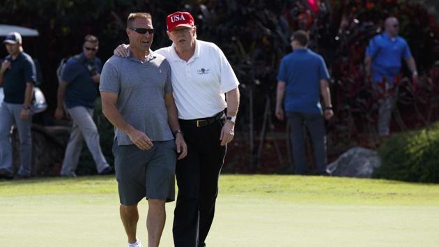 US President Donald Trump with Gene Gibson, commanding officer at Coast Guard Station Lake Worth Inlet, as he meets members of the US Coast Guard who he invited to play golf at Trump International Golf Club in West Palm Beach. (AP) US President Donald Trump with Gene Gibson, commanding officer at Coast Guard Station Lake Worth Inlet, as he meets members of the US Coast Guard who he invited to play golf at Trump International Golf Club in West Palm Beach. (AP)