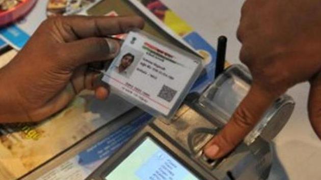 A visitor gives a thumb impression to withdraw money from his bank account with his Aadhaar or Unique Identification (UID) card in Hyderabad on January 18, 2017.(AFP)
