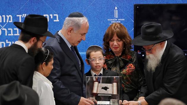 Moshe Holtzberg, who survived during the 2008 Mumbai attacks, presents a souvenir to Israeli Prime Minister Benjamin Netanyahu at Chabad House in Mumbai on January 18. (REUTERS) Moshe Holtzberg, who survived during the 2008 Mumbai attacks, presents a souvenir to Israeli Prime Minister Benjamin Netanyahu at Chabad House in Mumbai on January 18. (REUTERS)