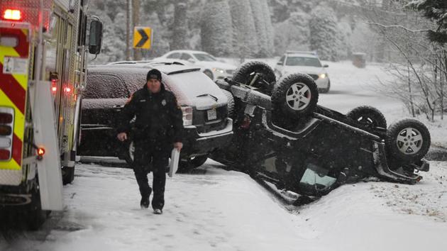 A police officer walks from the scene of an overturned Jeep after an accident on a snow-covered road in Richmond, Va., Wednesday, Jan. 17, 2018. A winter storm is making it's way through Virginia. (AP) A police officer walks from the scene of an overturned Jeep after an accident on a snow-covered road in Richmond, Va., Wednesday, Jan. 17, 2018. A winter storm is making it's way through Virginia. (AP)