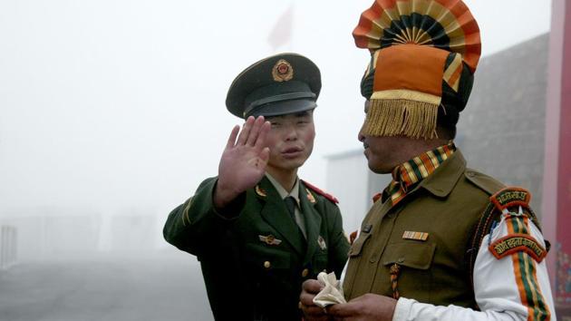File photo of a Chinese soldier gesturing next to an Indian soldier at the Nathu La border crossing in India's northeastern Sikkim state in July 2008. China said its construction activities in Doklam was legitimate.(AFP)