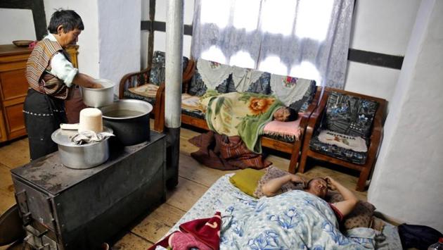 Farmer Ap Daw (R), 43, talks on his mobile phone as his son Sonam Tshering, 13, lies on a couch while his mother Aum Sangay, 68, heats water at their home in the Phobjikha Valley. “Children are spending more time on their mobile phones and not studying,” said Daw who also bemoans the rising mounds of trash by the highway. (Cathal McNaughton / REUTERS) Farmer Ap Daw (R), 43, talks on his mobile phone as his son Sonam Tshering, 13, lies on a couch while his mother Aum Sangay, 68, heats water at their home in the Phobjikha Valley. “Children are spending more time on their mobile phones and not studying,” said Daw who also bemoans the rising mounds of trash by the highway. (Cathal McNaughton / REUTERS)