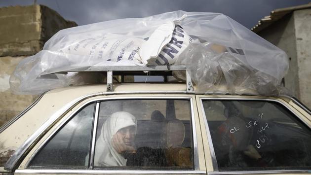 A Palestinian woman rides in a car after collecting aid provided by the UN agency for Palestinian refugees in Gaza City on January 17. (Mohammed Abed / AFP) A Palestinian woman rides in a car after collecting aid provided by the UN agency for Palestinian refugees in Gaza City on January 17. (Mohammed Abed / AFP)