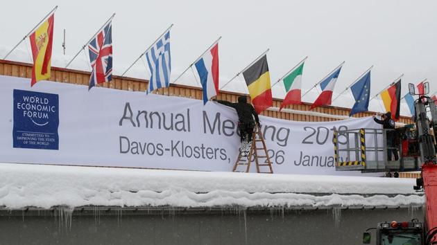 Workers fix a banner on the frontage of the congress centre, the venue of the upcoming World Economic Forum (WEF) in the Swiss mountain resort of Davos, Switzerland on January 18.(REUTERS)