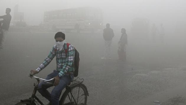 Commuters wait for transport amid a thick blanket of smog on the outskirts of New Delhi.(AP File Photo)
