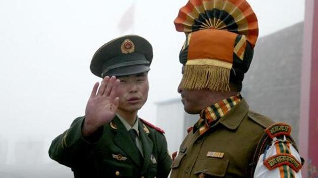 A Chinese soldier gestures next to an Indian soldier at the Nathu La border crossing between India and China in Sikkim.(AFP File Photo)
