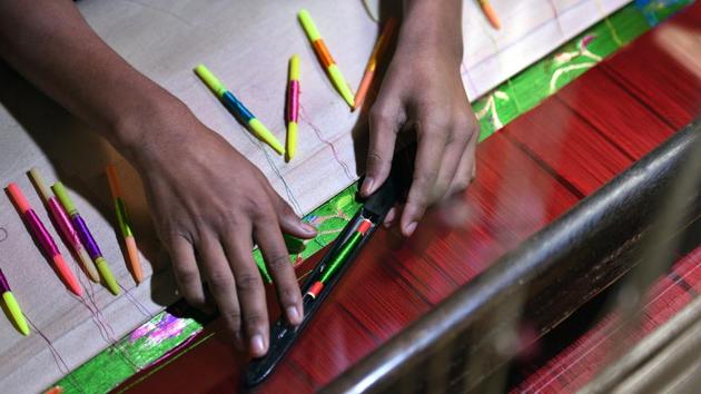 A weaving shuttle sits on an unfinished silk sari at a workshop. With electricity subsidies for powerloom users, competition from Surat’s textile mills, increased yarn prices and a faster, cheaper product from the newer looms, the traditional handloom industry has found it harder to hold on to its market share. (Raj K Raj / HT Photo) A weaving shuttle sits on an unfinished silk sari at a workshop. With electricity subsidies for powerloom users, competition from Surat’s textile mills, increased yarn prices and a faster, cheaper product from the newer looms, the traditional handloom industry has found it harder to hold on to its market share. (Raj K Raj / HT Photo)