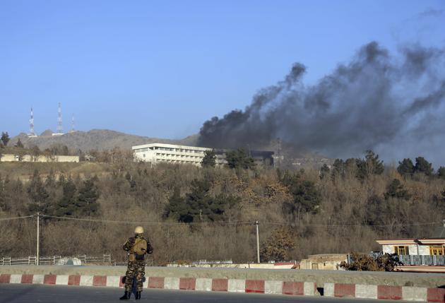 An Afghan security official stands guard as black smoke rises from the Intercontinental Hotel in Kabul on January 21, 2018. (AP) An Afghan security official stands guard as black smoke rises from the Intercontinental Hotel in Kabul on January 21, 2018. (AP)