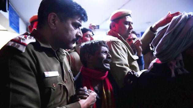 Policemen comfort a relative mourning the death of victim at a hospital after a two-storey cracker factory caught fire in north Delhi's Bawana industrial area on Saturday. (PTI) Policemen comfort a relative mourning the death of victim at a hospital after a two-storey cracker factory caught fire in north Delhi's Bawana industrial area on Saturday. (PTI)