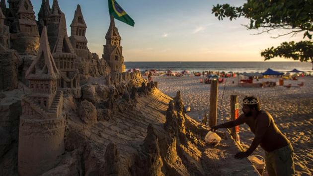 As he retouches a turret here, adjusts a majestic gate there, Marcio believes he has everything he needs. The only problem is the unbearable summer sun. He sprinkles water on the walls to keep them firm in the baking heat, which on a recent afternoon reached 40 degrees Celsius. (Mauro Pimentel / AFP) As he retouches a turret here, adjusts a majestic gate there, Marcio believes he has everything he needs. The only problem is the unbearable summer sun. He sprinkles water on the walls to keep them firm in the baking heat, which on a recent afternoon reached 40 degrees Celsius. (Mauro Pimentel / AFP)