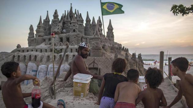 Marcio speaks with children interested in his sand castle. To make a living, he put a box for donations at the entrance to his sandcastle which people often rob. “I used to get angry... but I started living with that paranoia, and I don’t want that. I do this for pleasure,” he said. From time to time, a shopping centre pays him to make one of his sand sculptures for special events. (Mauro Pimentel / AFP) Marcio speaks with children interested in his sand castle. To make a living, he put a box for donations at the entrance to his sandcastle which people often rob. “I used to get angry... but I started living with that paranoia, and I don’t want that. I do this for pleasure,” he said. From time to time, a shopping centre pays him to make one of his sand sculptures for special events. (Mauro Pimentel / AFP)