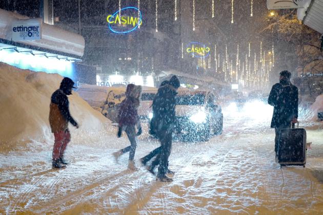 People walk through heavy snow fall in the resort town of Davos. (AFP) People walk through heavy snow fall in the resort town of Davos. (AFP)