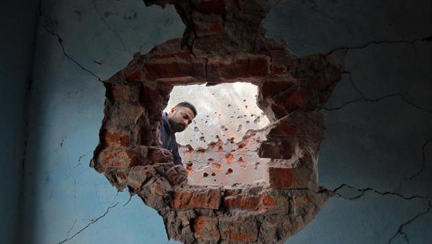 A man looks at the wall of his house that was damaged by firing from the Pakistan side of the border at Kanachak in Akhnoor Sector on the outskirts of Jammu.(Reuters Photo)