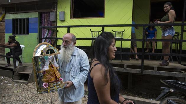 Pablo Zabala, walks to the Barrio Chino bar to return a statue of a saint, adopted by the local sex workers as their patron, that he volunteered to clean. He cuts an eccentric figure dressed in light pajamas and says he had long felt compelled to work not just with the righteous, but with the sinners, and connect with “the life of the common people.” (Rodrigo Abd / AP) Pablo Zabala, walks to the Barrio Chino bar to return a statue of a saint, adopted by the local sex workers as their patron, that he volunteered to clean. He cuts an eccentric figure dressed in light pajamas and says he had long felt compelled to work not just with the righteous, but with the sinners, and connect with “the life of the common people.” (Rodrigo Abd / AP)