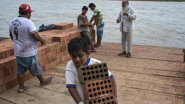 Father Pablo Zabala chats with workers offloading bricks on the Inambari River, in Puerto Carlos. Indigenous leaders who met Francis on Friday hope he will push Peru’s government to grant them formal land rights and clean up the polluted rivers miners have left in their wake. Zabala said that for the 85,000 families who survive by mining gold in the Amazon the problem of poverty and limited opportunities takes priority. (Rodrigo Abd / AP) Father Pablo Zabala chats with workers offloading bricks on the Inambari River, in Puerto Carlos. Indigenous leaders who met Francis on Friday hope he will push Peru’s government to grant them formal land rights and clean up the polluted rivers miners have left in their wake. Zabala said that for the 85,000 families who survive by mining gold in the Amazon the problem of poverty and limited opportunities takes priority. (Rodrigo Abd / AP)
