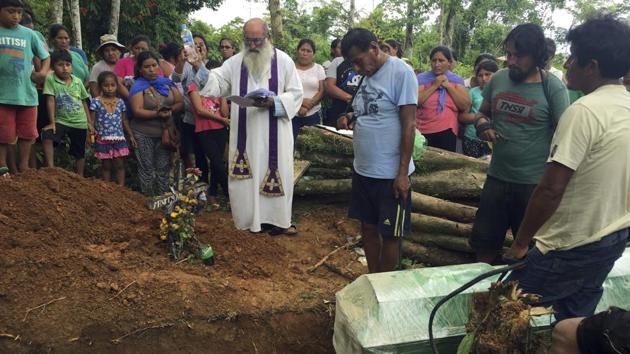 Below a canopy of trees in the Peruvian Amazon, drunken miners carry in the casket of a man whose search for gold ended with a bullet in his stomach. 70-year-old Spanish Reverend Pablo Zabala presides over the funeral, singing as the coffin is lowered into the dirt in a cemetery where the graves of about 50 other illegal miners are marked with plain black crosses. (Franklin Briceno / AP) Below a canopy of trees in the Peruvian Amazon, drunken miners carry in the casket of a man whose search for gold ended with a bullet in his stomach. 70-year-old Spanish Reverend Pablo Zabala presides over the funeral, singing as the coffin is lowered into the dirt in a cemetery where the graves of about 50 other illegal miners are marked with plain black crosses. (Franklin Briceno / AP)